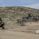 A Green Beret on a ATV assigned to the 1st Special Forces Group (Airborne) trains with a Stryker Interim Armored Vehicle from 2nd Stryker Brigade Combat Team.